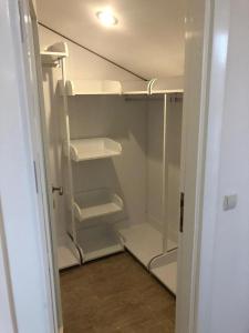 un armario vacío con estanterías blancas y una puerta en Modern and Cozy Dublex in Amazing Facility, en Belek