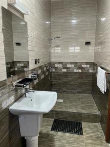 y baño con lavabo y ducha. en Havana Hôtel en Morondava