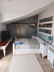 1 dormitorio con 1 cama blanca y TV en Modern and Cozy Dublex in Amazing Facility, en Belek