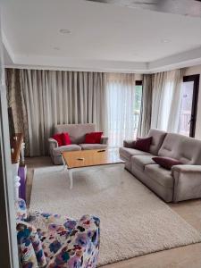 Sala de estar con 2 sofás y mesa de centro en Modern and Cozy Dublex in Amazing Facility, en Belek