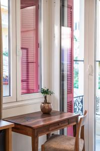 - une table avec une plante dans une pièce dotée de fenêtres dans l'établissement Silo Luxury Rooms, à Nauplie