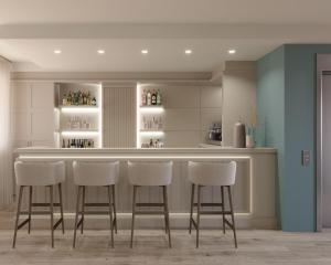 a kitchen with a bar with four stools at PFA Hotel Viareggio in Viareggio