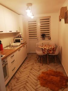 a small kitchen with a table and chairs in it at Bee Studio in Iernut