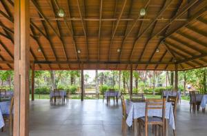 uma sala de jantar com mesas e cadeiras num pavilhão em WAKAYA ECOLODGE em Pucallpa