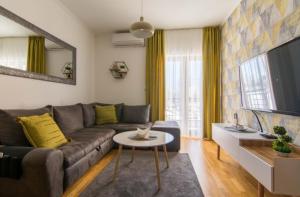 ズラティボールにあるApartman ČAROBNI BREGのソファとテーブルのあるリビングルーム