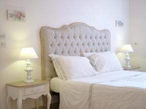 1 dormitorio con 1 cama blanca grande y 2 lámparas en Masseria Cappuccini en Ostuni