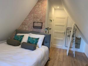 een slaapkamer met een bed met 2 kussens en een trap bij B&B bij Vincent in Nieuw-Amsterdam