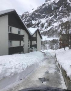 une maison avec une allée couverte de neige devant elle dans l'établissement Holiday 88, à Loèche-les-Bains