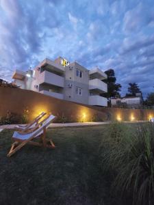 a bench sitting in the grass in front of a building at By Muni Apartamentos Premium in Tanti
