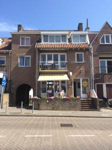 een bakstenen gebouw met een balkon in een straat bij Hotel Noordzee in Zandvoort