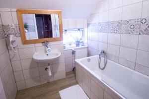 a bathroom with a sink and a tub and a mirror at Penzion Sofinata & Pizzeria Špindlerův Mlýn in Špindlerův Mlýn