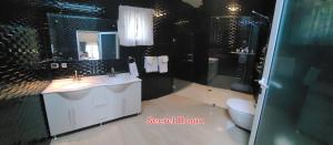a bathroom with two sinks and a toilet and a mirror at casaenjoysamana in Los Naranjos