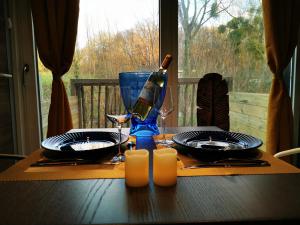 a table with a bottle of wine and glasses on it at BRUSHWOOD in Longfossé