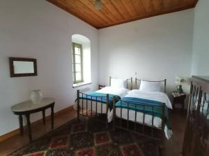a bedroom with two beds and a table and a window at The Doctor’s Mansion - Arkadia in Lagkadia