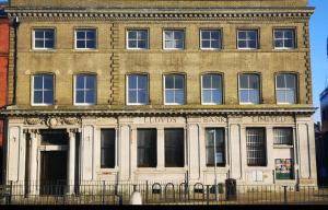 a large brick building with a fence in front of it at Entire Two Double Bedrooms Flat with River Yare View H6 in Great Yarmouth