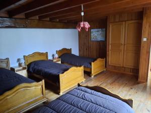 four beds in a room with wooden floors at LES HIRONDELLES - Les gîtes du Der - in Puellemontier