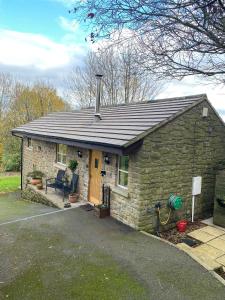 una pequeña casa de ladrillo con puerta amarilla en The Stables en Ashover