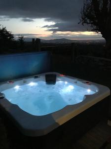 a jacuzzi tub in a backyard at night at Mc Courts Cottage in Hilltown