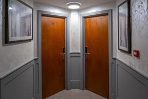 two wooden doors in a hallway with paintings at Magnolia House, Rye in Rye