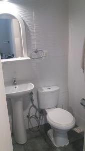 Baño blanco con aseo y lavamanos en Apartamento-Loft, en Mercedes