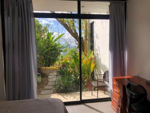 una camera da letto con porta che si apre su un giardino di Casa Marlui-San José a Curridabat