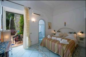 a bedroom with a bed and a large window at Villa SEASIDE in Praiano