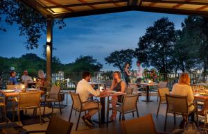 Un grupo de personas sentadas en mesas en un patio. en Sunflower Camping, en Novigrad Istria