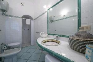 a bathroom with a sink and a toilet and a mirror at Villa SEASIDE in Praiano