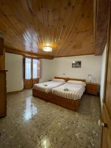 a bedroom with a large bed with a wooden ceiling at Can Xuneta in Bagá