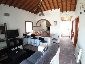 a living room with a couch and a kitchen at Casa Malbusca in Almagrinha