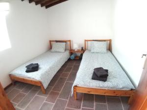 two twin beds sitting in a room with at Casa Malbusca in Almagrinha