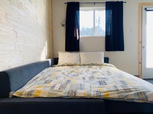 - un lit avec une couverture colorée dans l'établissement Attitude Montagne, à Saint-Adolphe-d'Howard