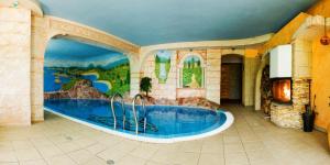uma grande piscina num quarto com uma pintura na parede em Perła Karkonoszy SPA em Karpacz