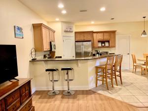 a kitchen with wooden cabinets and a bar with stools at Cape Canaveral near Beach House in Cape Canaveral