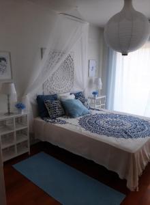 a bedroom with a bed with blue pillows and a window at Férias de Sonho in Arcos de Valdevez