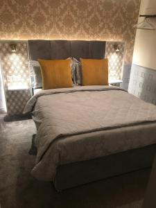 ein großes Bett mit orangefarbenen Kissen im Schlafzimmer in der Unterkunft Mary Ann's Ballyheigue Cottage in Tralee