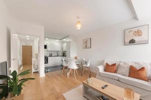 a white living room with a couch and a table at Spacious Two Bed loft Apartment in Birchanger