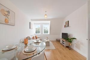 a white living room with a dining room table at Spacious Two Bed loft Apartment in Birchanger