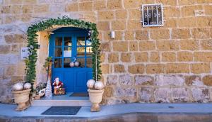 a blue door on a stone building with a window at Fiftyfour West Boutique Living in Għarb