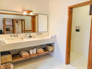 a bathroom with a sink and a mirror at Dune Boutique Hotel located at the party zone in Tulum