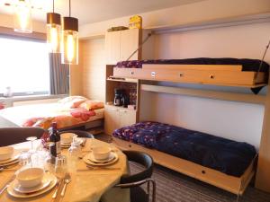 a room with a dining table and a bunk bed at Zeezicht Studio Alisa in Blankenberge