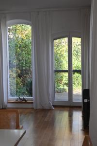 a living room with two large windows and a wooden floor at Kuhstall mit Schick in Geschendorf