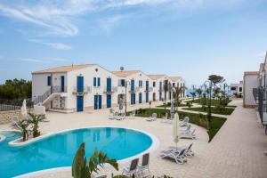 a villa with a swimming pool in front of a building at Scala Dei Turchi Resort in Realmonte