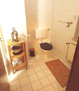 a bathroom with a toilet with a black seat at Stadthotel in Rochlitz