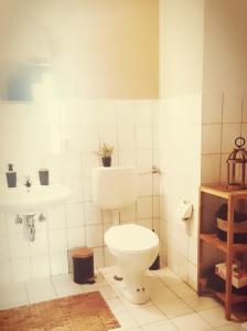 a bathroom with a toilet and a sink at Stadthotel in Rochlitz