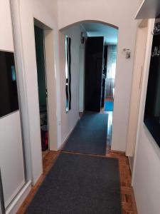 un corridoio con pareti bianche e un tappeto nero di Apartman Dominik a Zagabria