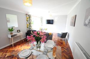 a living room with a table and flowers on it at Newly refurbished next to University Hospital Coventry in Walsgrave on Sowe