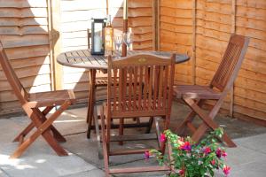 a wooden table with two chairs and a tea kettle on it at Newly refurbished next to University Hospital Coventry in Walsgrave on Sowe