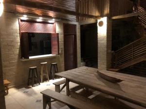 a wooden table in a room with a television and stools at Casa los Almendros in Guamo
