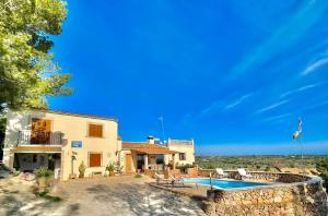 a villa with a swimming pool and a house at es cau in Manacor